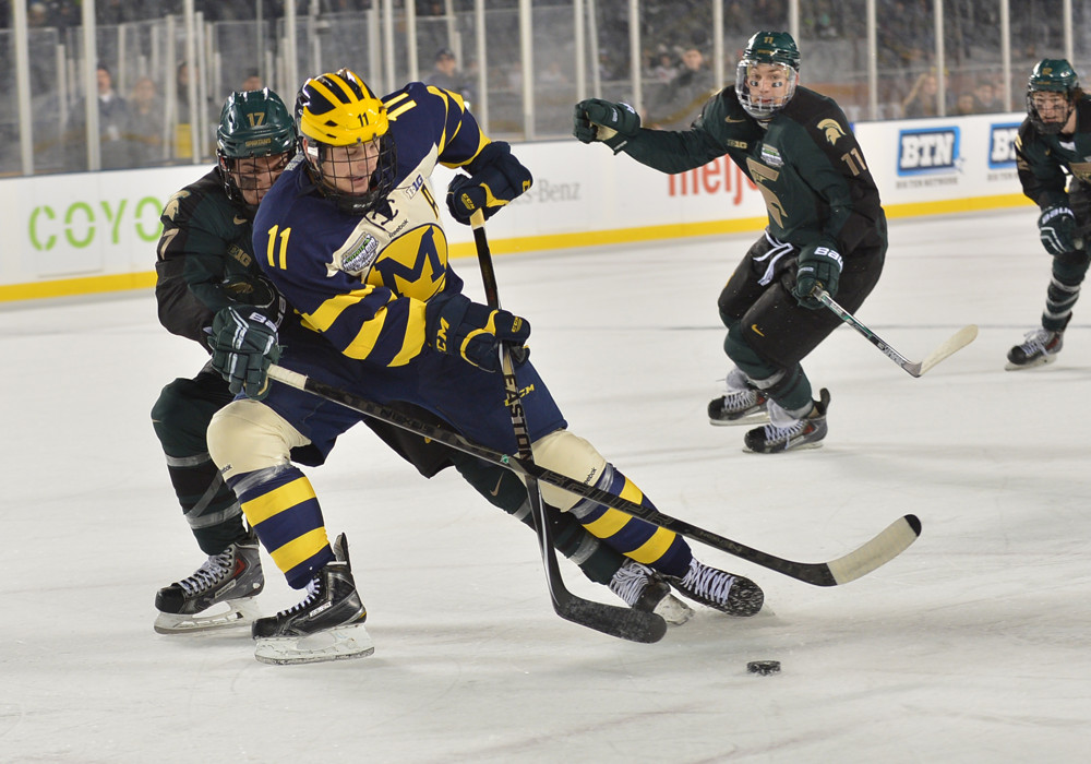 February  07, 2015: Michigan forward Zach Hyman #11 handles the puck against Michigan State defenseman Brock Krygier #17 during the Michigan Wolverines  game versus the Michigan State Spartans in the Hockey City Classic at Soldier Field in Chicago, IL. Michigan wins against Michigan State, 4-1.
